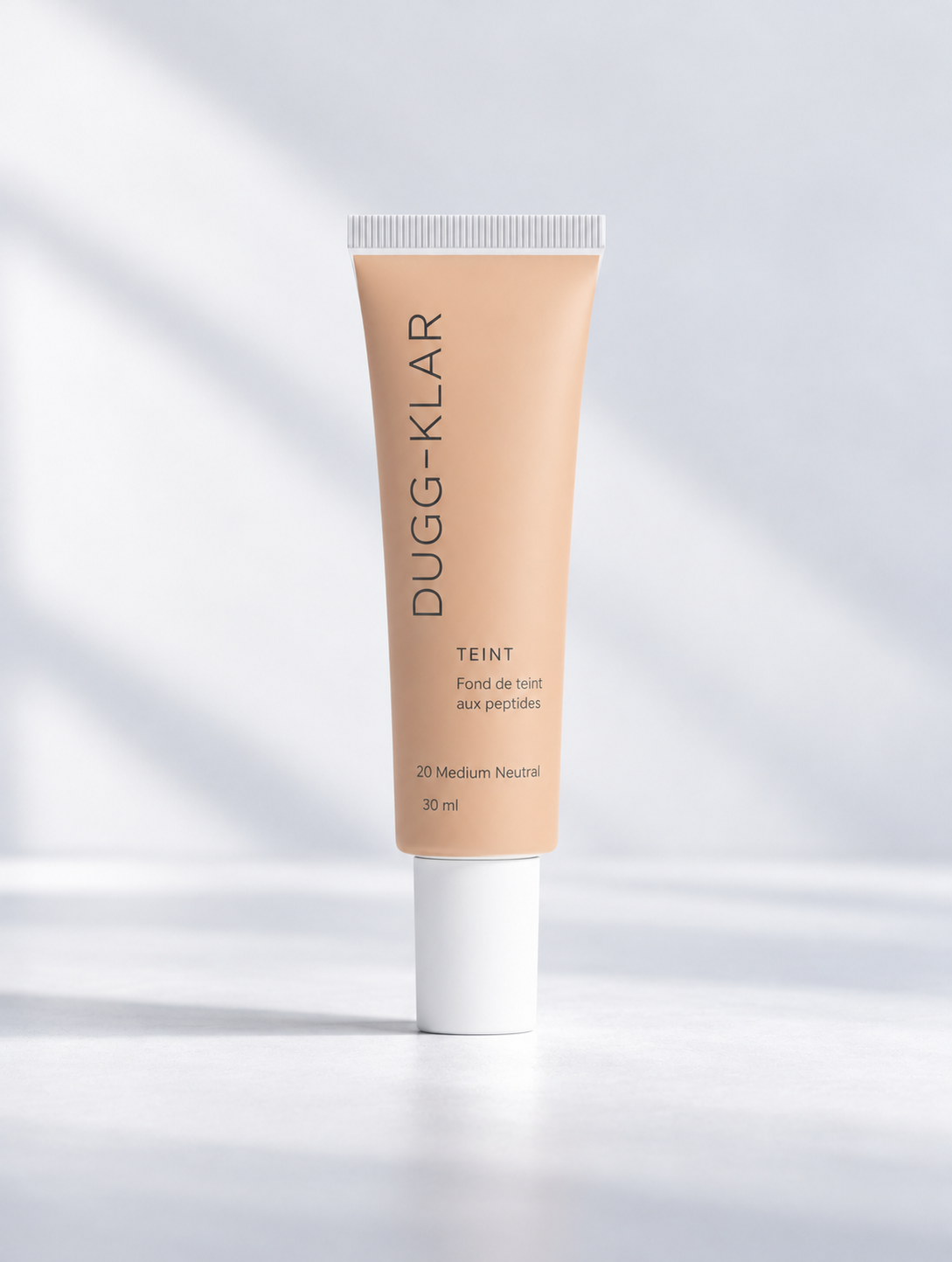 DUGG-KLAR, fond de teint aux peptides 30 ml, teinte 20 Medium Neutral, tube beige à bouchon blanc et logo fin gris ardoise.