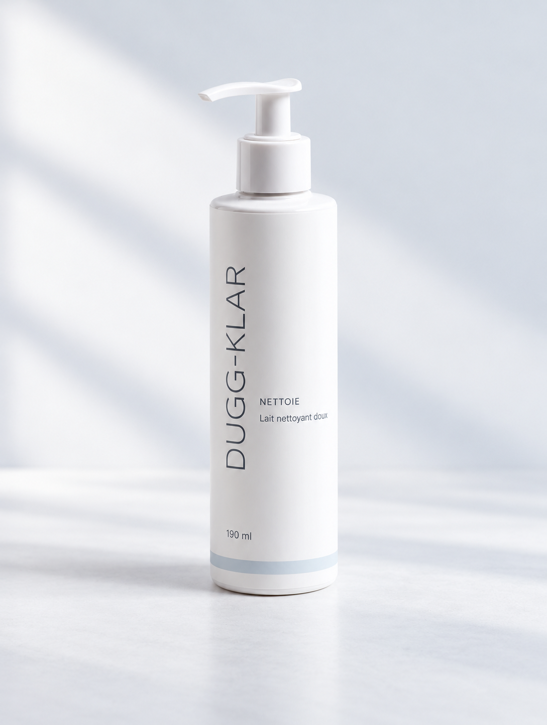 DUGG-KLAR, lait nettoyant doux 190 ml, flacon blanc à pompe blanche et logo fin gris ardoise.
